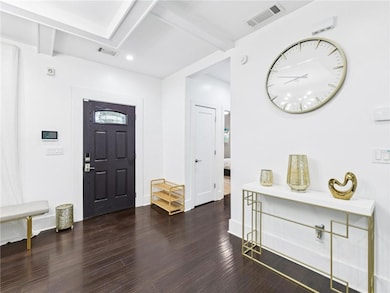 Entryway featuring beamed ceiling, dark wood finished floors, and recessed lighting