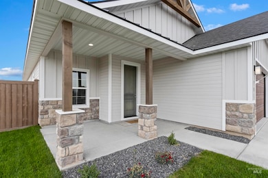 View of exterior entry featuring board and batten siding, covered porch, and stone siding