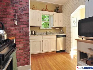 White kitchen has wood Floors, a pantry and a sunny Breakfast Nook