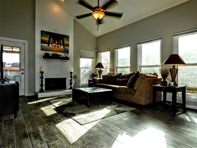 Living room featuring a fireplace, ceiling fan and