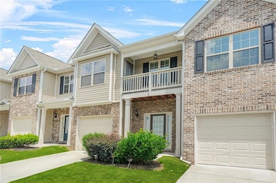 View of front of house with a balcony, a garage, and driveway