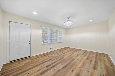 Unfurnished room featuring light hardwood / wood-style floors and a chandelier