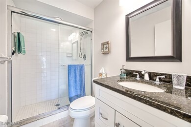 Bathroom with a shower stall, toilet, and vanity
