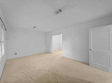 Living room with ornamental molding, light carpet,