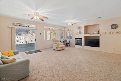 Carpeted Great room featuring ceiling fan, a tile