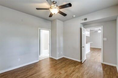 Empty room with a ceiling fan and wood finished floors