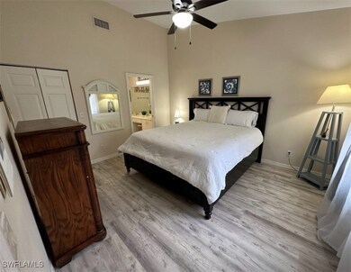 Bedroom with baseboards, light wood-style flooring, visible vents, and ceiling fan