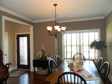 Dining Room: 12 x 14  Elegant Dining Area with hardwood flooring,  gorgeous view of the front yard, wood blinds, crown molding, cased opening to the foyer Area and   Kitchen.  