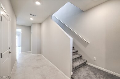 Staircase with tile patterned floors, visible vent