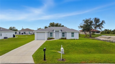 View of front of home with driveway, a front lawn, a garage, and stucco siding