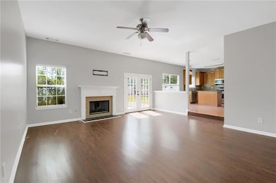 living room with dark wood-style flooring, a premium fireplace, ceiling fan, and french doors