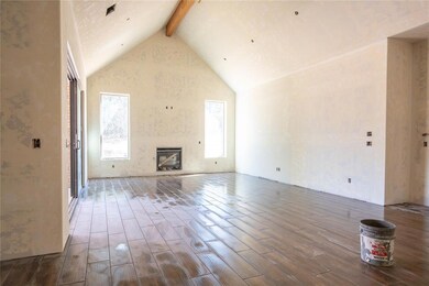 Unfurnished living room featuring beamed ceiling, 