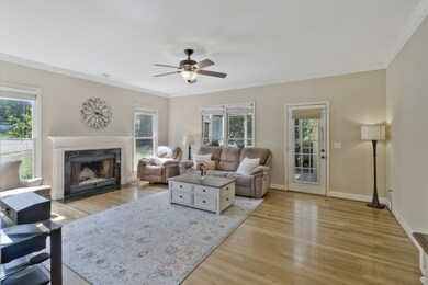Spacious family room with fireplace, hardwood floors and door leading to the screened in porch