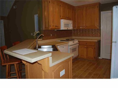 The kitchen is open to great room and sports new hardwood porcelain tile, breakfast bar and copper backsplash