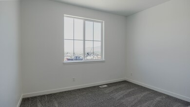 Unfurnished room featuring dark colored carpet and baseboards