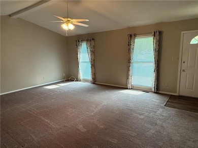 Carpeted spare room featuring healthy amount of natural light and a ceiling fan