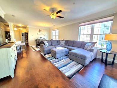 Living room with dark wood-type flooring, crown mo