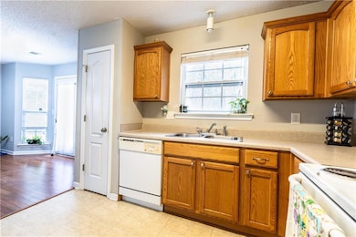 Kitchen with a sink, brown cabinets, and dishwashe