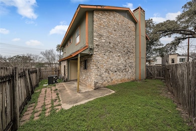 Rear view of house with stone siding, a fenced ba
