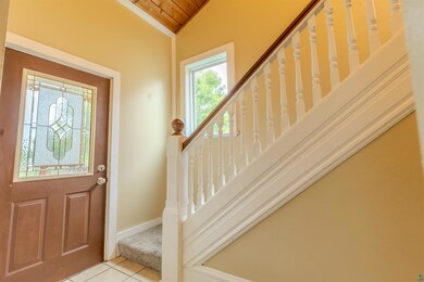 Foyer entrance featuring wooden ceiling, lofted ceiling, tile patterned flooring, and stairs