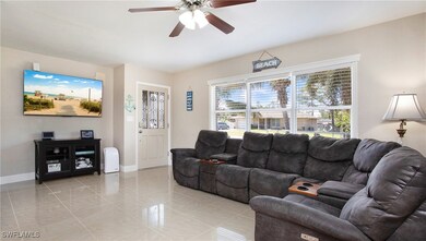 Living area featuring a ceiling fan and baseboards