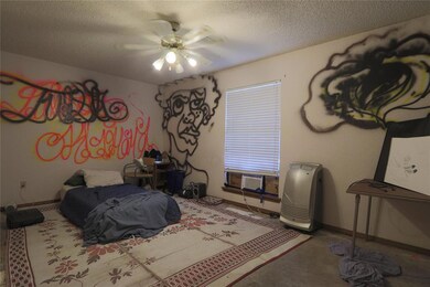 Bedroom with a textured ceiling and ceiling fan