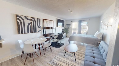 Bedroom featuring a textured ceiling, light hardwo