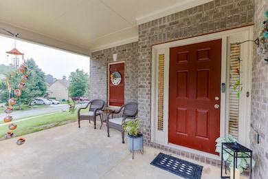 Doorway to property featuring a porch and brick siding