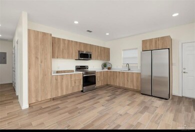 Unfurnished living room with baseboards, a sink, ceiling fan, light wood finished floors, and recessed lighting