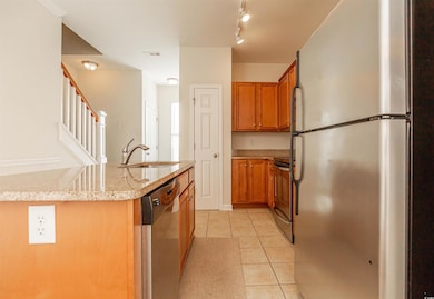 Kitchen with brown cabinets, appliances with stain