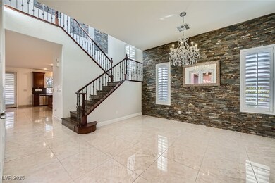 Foyer with marble finish floor, a notable chandeli