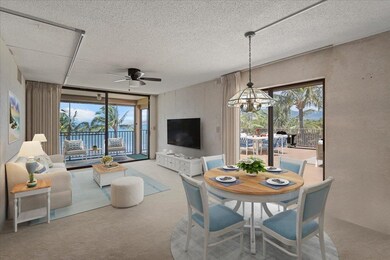 Living room with ocean view & direct access to both lanais- Virtually Staged