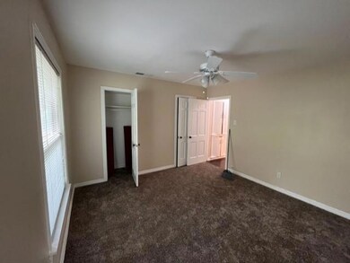 Unfurnished bedroom featuring ceiling fan and dark