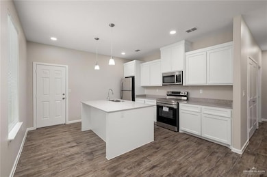 Kitchen featuring stainless steel appliances, a sink, baseboards, dark wood-style floors, and recessed lighting