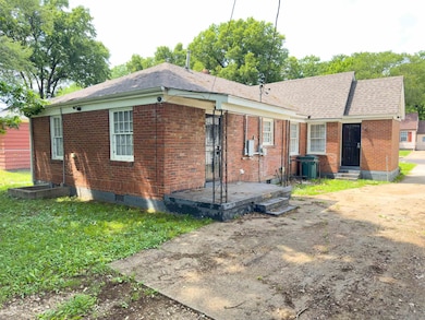 Rear view of property featuring brick siding and a shingled roof