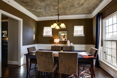 The Formal Dining Room is open to the Foyer and offers traditional elements such as a chair rail with wainscoting and crown molding with drop detail. Other notable features include a faux finish ceiling and an oil rubbed bronze light fixture.