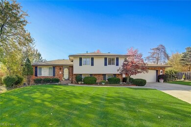 Split level home featuring a garage and a front yard