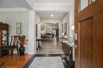 Foyer entrance featuring crown molding, dark wood-style flooring, and a fireplace