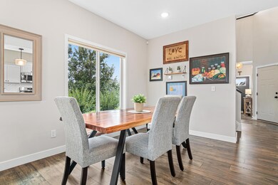 Bright informal dining room for large or small groups with big window to see the pretty landscaping on the side of the home.