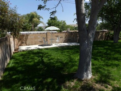 Great backyard with new lush green grass and mature trees.