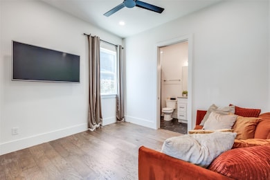 Bedroom with ensuite bathroom, ceiling fan, and ha