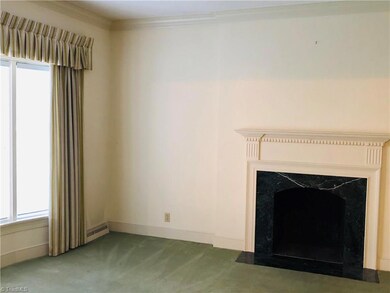 Living room has a bay window and a Faux fireplace.