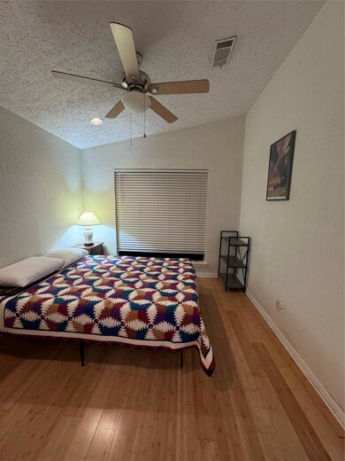 Bedroom featuring visible vents, a textured ceili