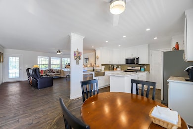 Dining room with ceiling fan, dark wood finished floors, recessed lighting, and ornamental molding