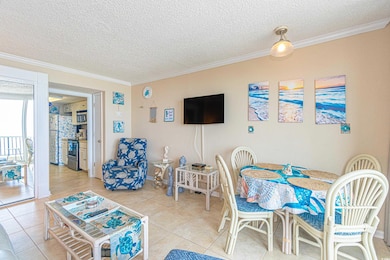 Living area with crown molding, light tile pattern