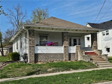 Front featuring roof with shingles and covered porch