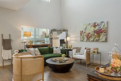 Living room featuring a high ceiling and hardwood 