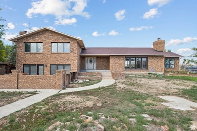 View of front of property featuring a chimney and brick siding