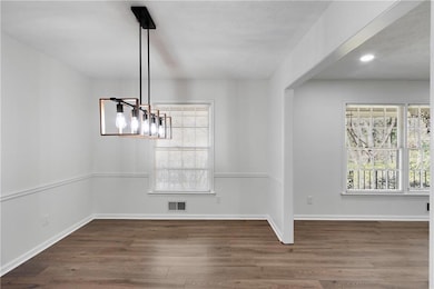 Unfurnished dining area featuring visible vents, b