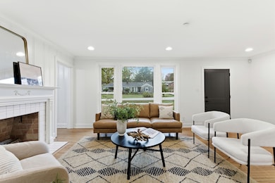 Step inside the sunlit living room. Wide windows offer a glimpse of your peaceful street.
